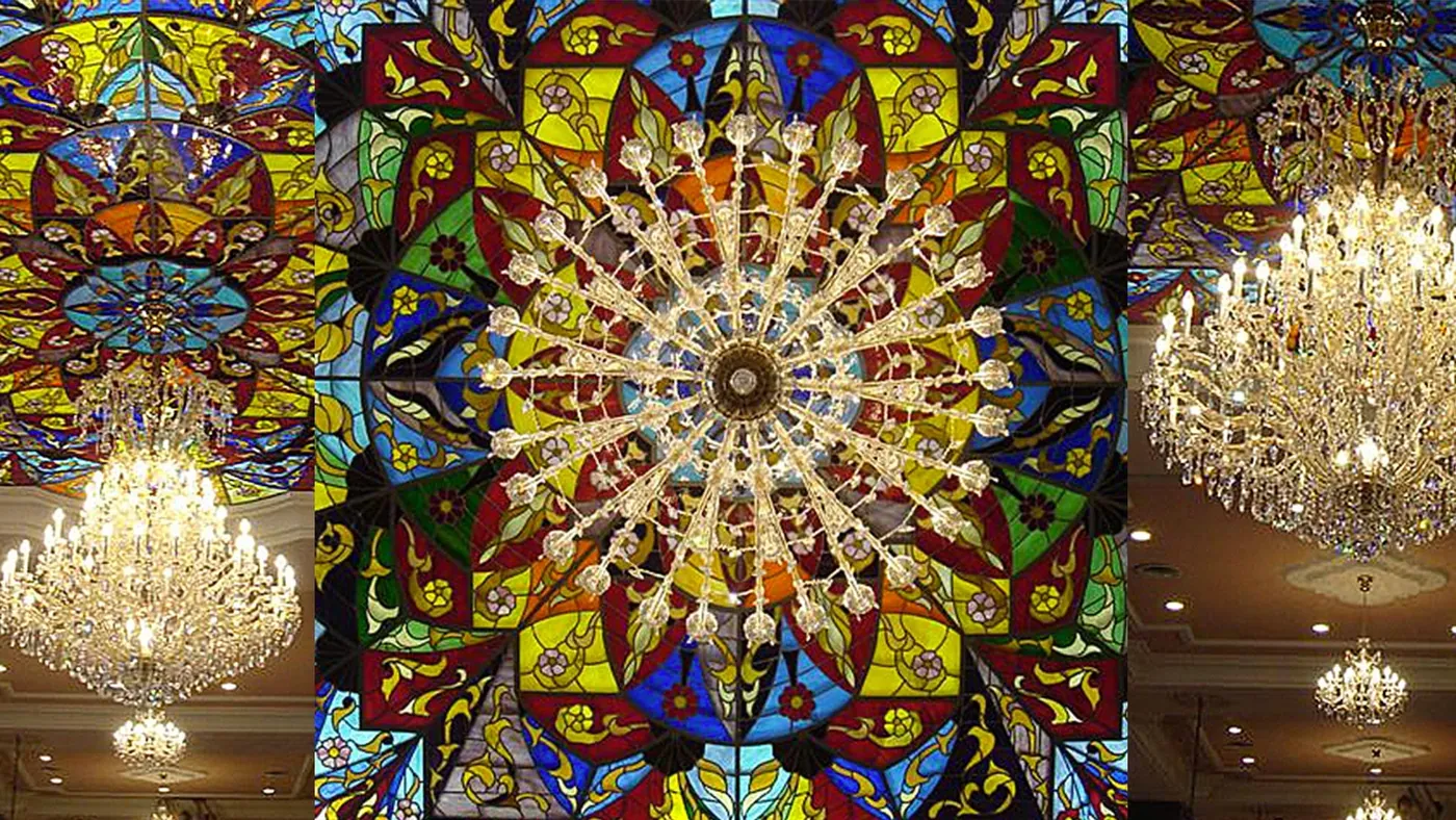 Dettaglio della volta in vetro colorato con i lampadari in cristallo sospesi.