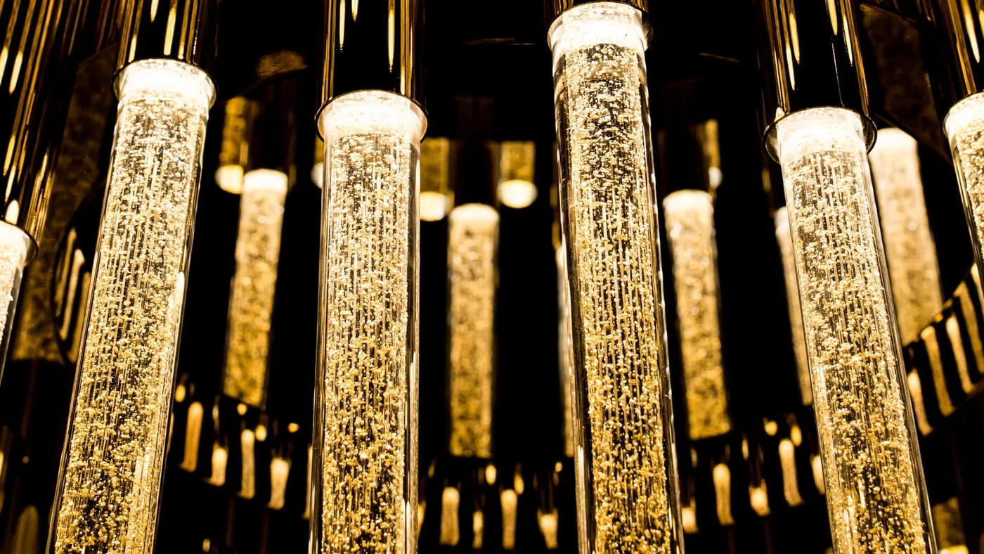 Collezione New York: tubi in vetro di Murano con foglia oro su struttura dorata.