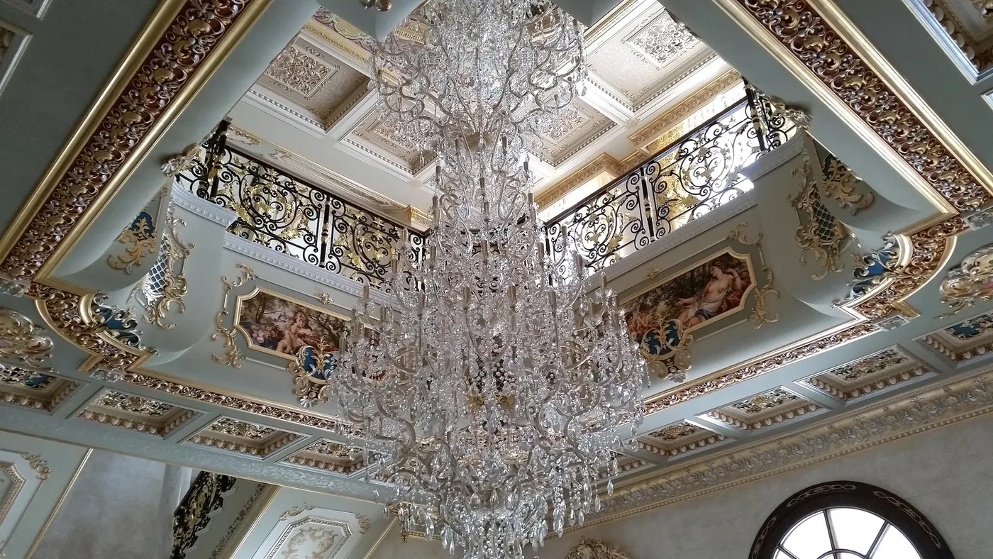 Volta affrescata di una villa privata con una cascata di cristallo vista dal basso.
