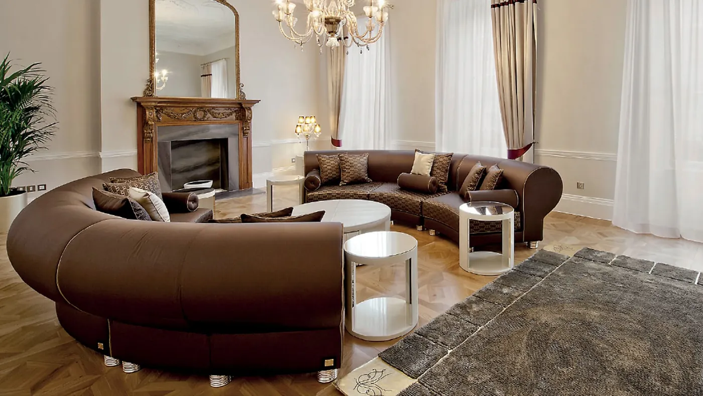 Salone di una residenza privata con camino, specchio e lampadario in cristallo.