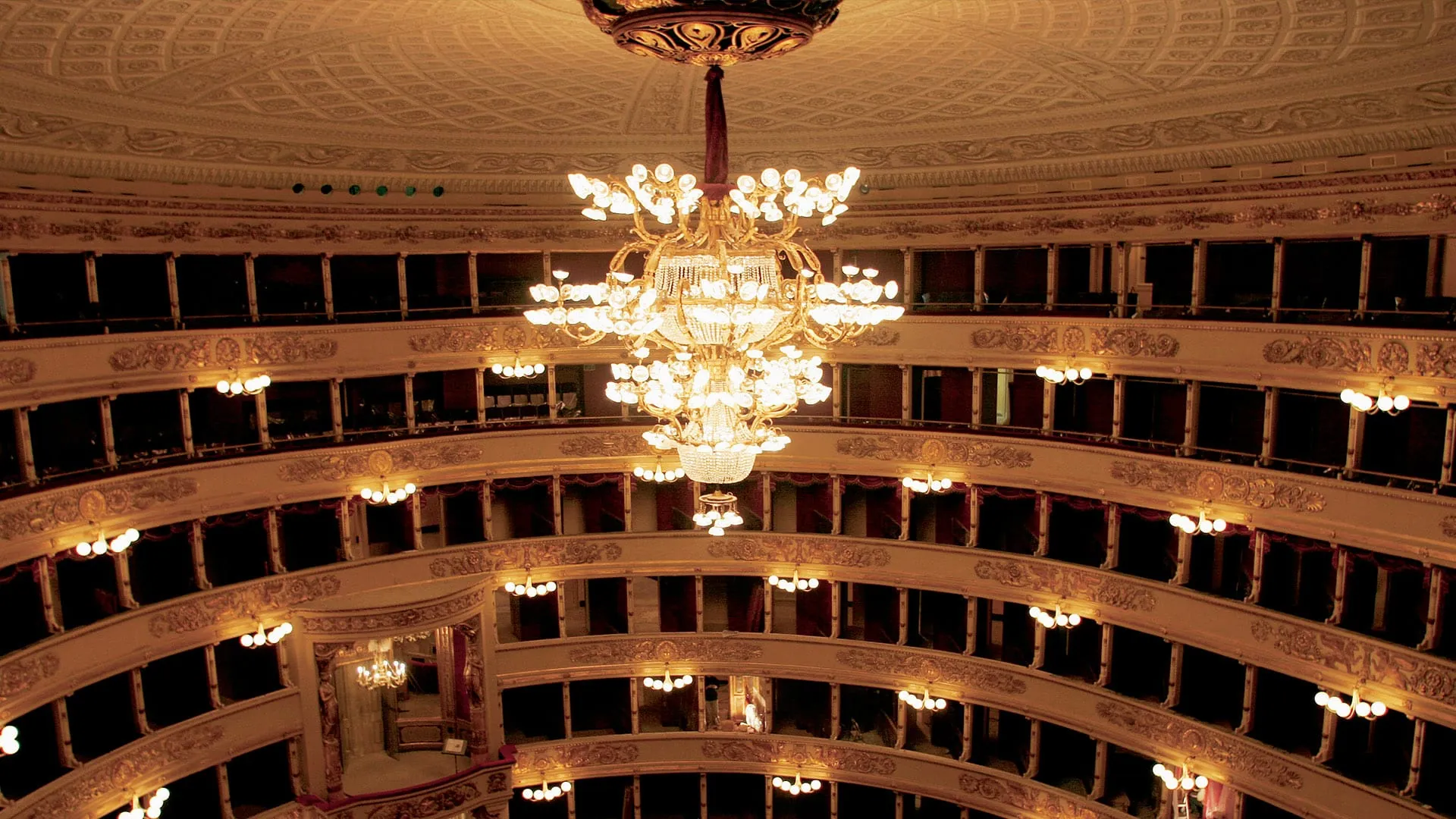 La sala del Teatro alla Scala di Milano con gli ordini di palchi illuminati.
